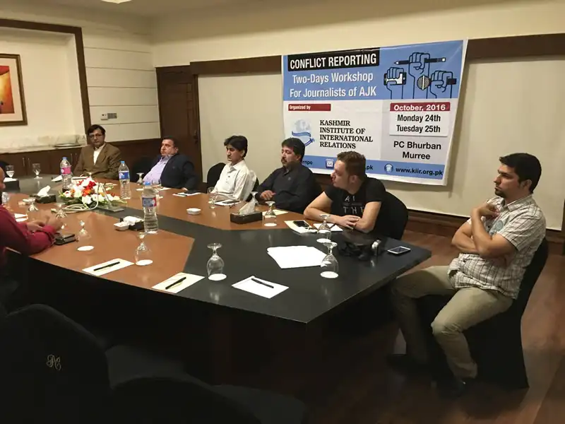 Journalists using digital devices in Muzaffarabad newsroom
