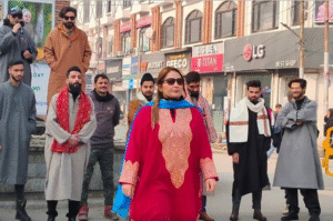 A woman at Srinagar’s Lal Chowk wearing a deep red traditional Kashmiri pheran with intricate Kashida embroidery during the International Pheran Day show.
