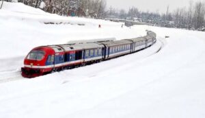 Train passing through snow-covered mountains in Kashmir