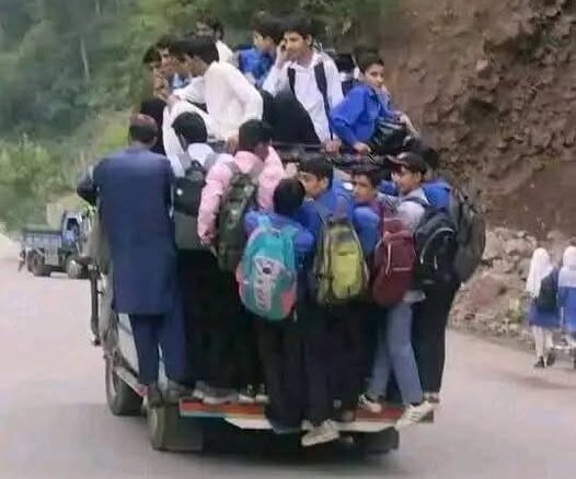 Schoolchildren riding on the back of a jeep in the hilly roads of Pakistan-administered Kashmir