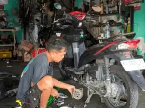 Person maintaining and cleaning a mountain bike at home.