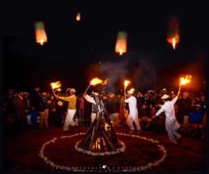 People standing near a bonfire during the Jashn-e-Mayfung festival in Baltistan, celebrating the Balti New Year with fire and community gathering.