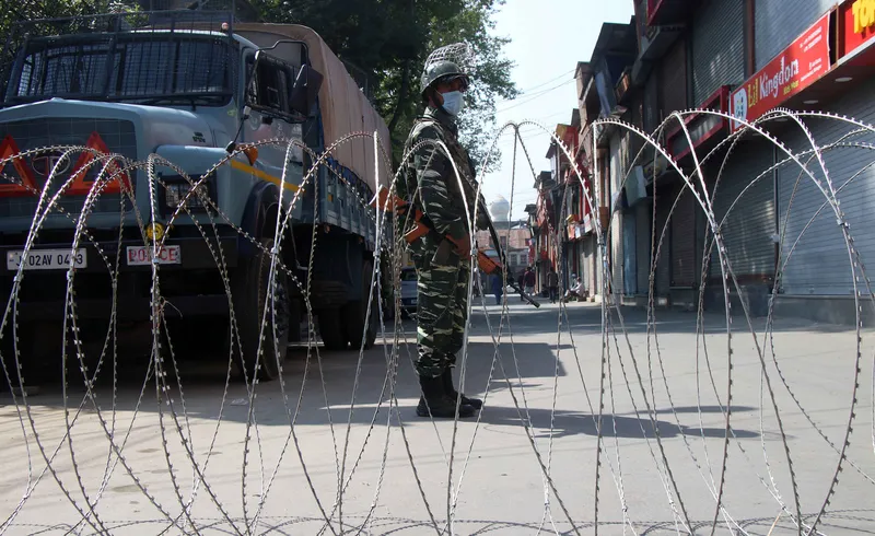 View of Lal Chowk, Srinagar, Indian-administered Kashmir, showing barbed wire barricades, military vehicles, and a soldier on duty – Photo credit: KashmirUzma